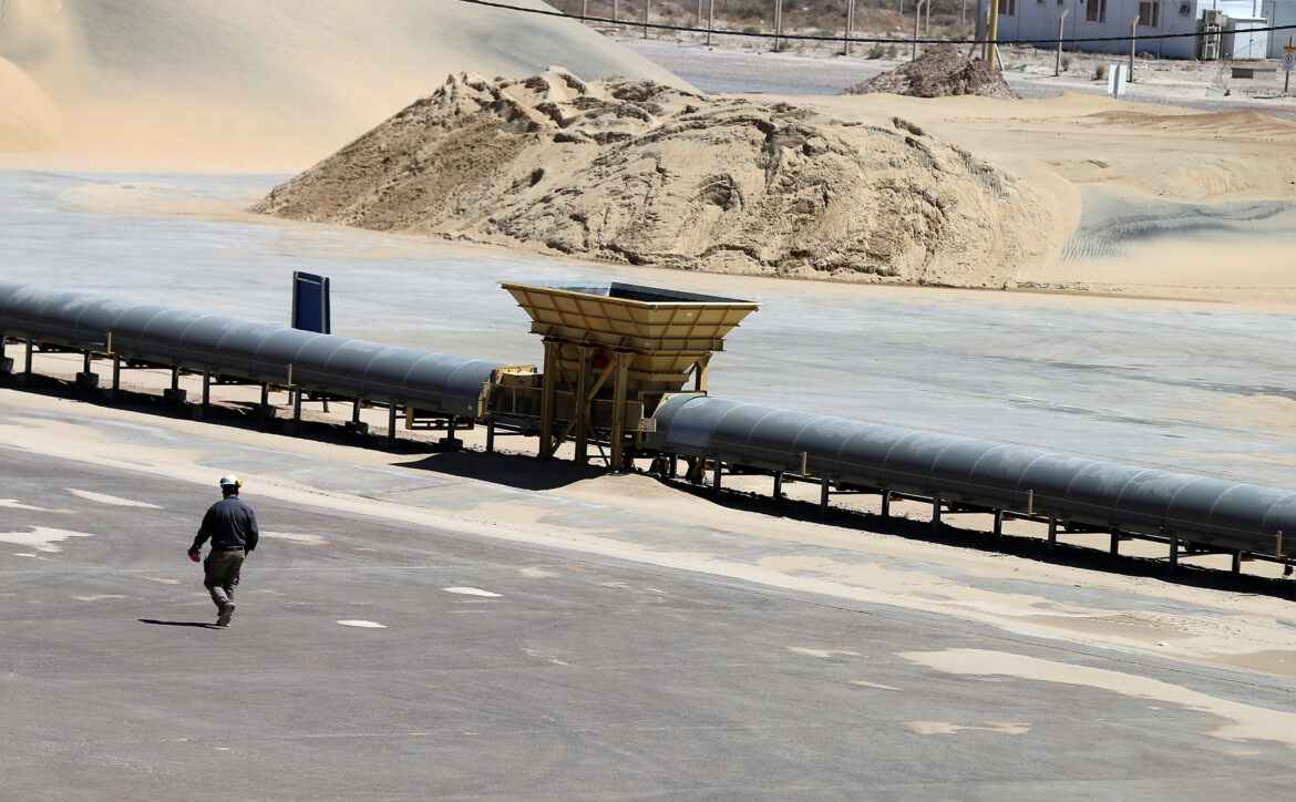 A worker walks near a pile of sand at Vaca Muerta shale oil and gas drilling, in the Patagonian province of Neuquen, Argentina January 21, 2019. Picture taken January 21, 2019. REUTERS/Agustin Marcarian