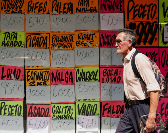 FILE PHOTO: A man walks past signs advertising meat cuts prices outside a butcher's shop, as Argentina is battling with an annual inflation heading towards 200%, in Buenos Aires, Argentina January 8, 2024. REUTERS/Agustin Marcarian/File Photo