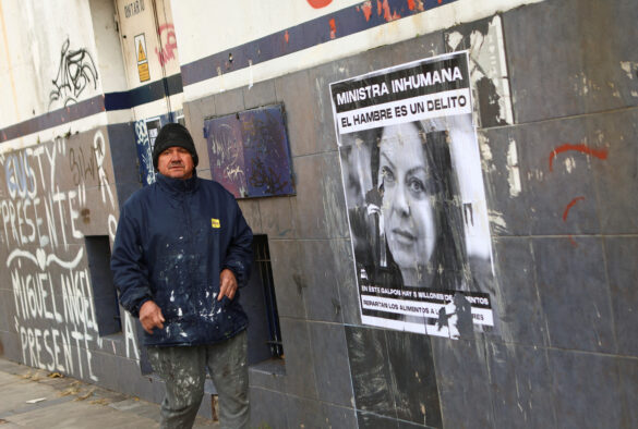 A man walks past a placard on the wall depicting Argentine Minister of Human Capital Sandra Pettovello that reads "Inhuman minister, the hunger is a crime", outside a warehouse where aid food is withheld by the government, in Buenos Aires, Argentina, June 4, 2024. REUTERS/Matias Baglietto