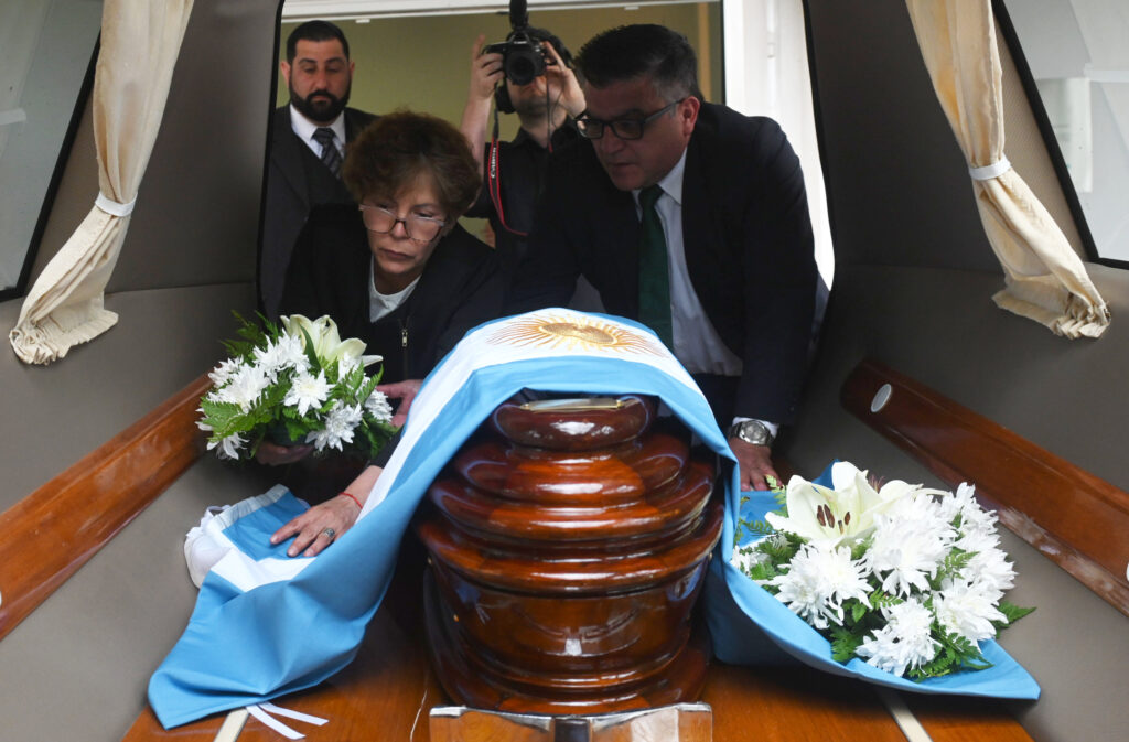 A coffin carrying Benito Romano's remains is placed in the hearse. Credit: courtesy of the Argentine Forensic Anthropology Team
